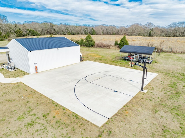 view of sport court featuring a yard and basketball hoop