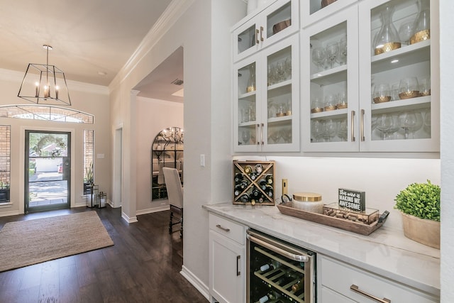 foyer entrance featuring wine cooler, a bar, dark wood-style floors, and ornamental molding