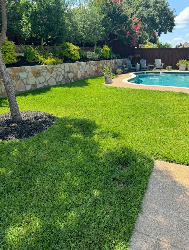 view of yard with fence and a fenced in pool