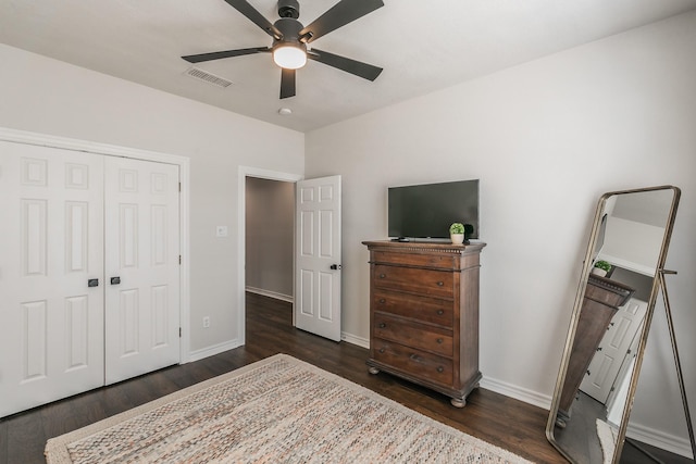 bedroom featuring visible vents, baseboards, a closet, dark wood-style floors, and a ceiling fan