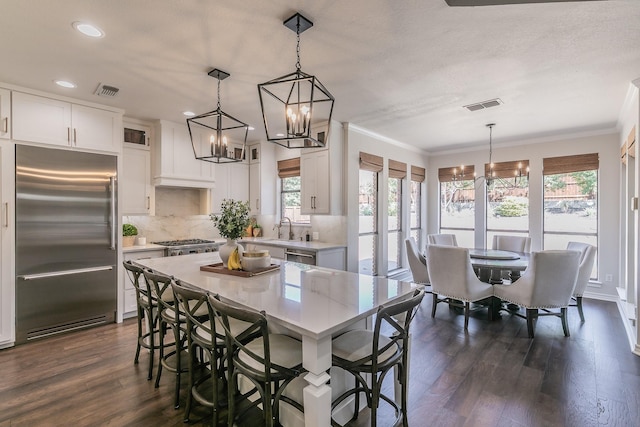 kitchen featuring backsplash, stainless steel appliances, a notable chandelier, and visible vents