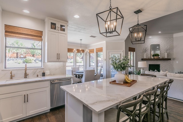 kitchen featuring dishwasher, white cabinets, a notable chandelier, and a sink