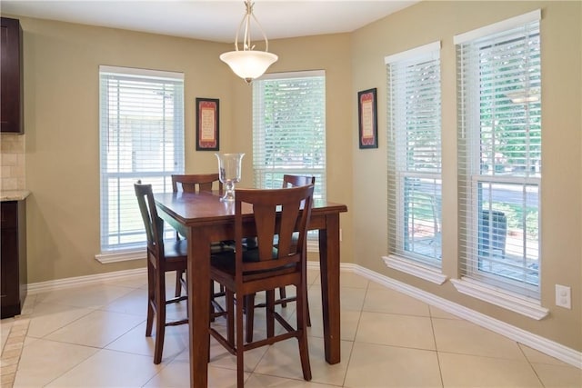 dining space with light tile patterned floors and baseboards