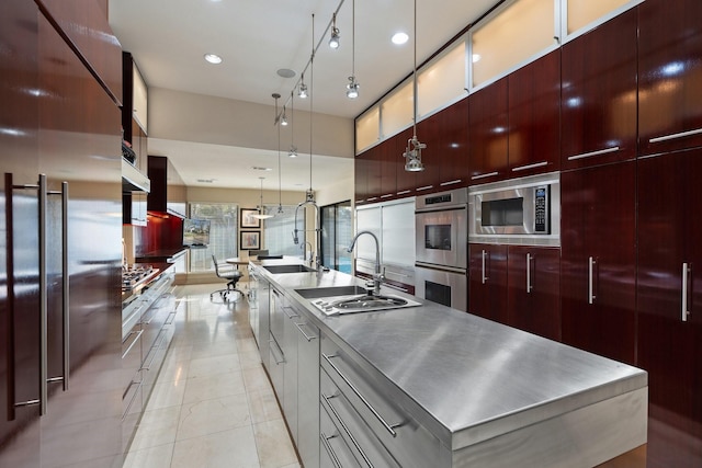 kitchen with a large island, stainless steel appliances, stainless steel countertops, a sink, and modern cabinets