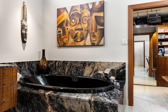 full bath with a garden tub and tile patterned floors