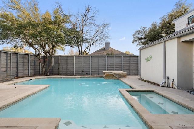 view of swimming pool featuring a patio area, a fenced backyard, and a pool with connected hot tub