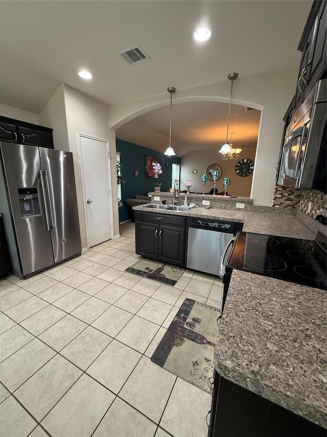 kitchen with stainless steel appliances, visible vents, light tile patterned flooring, a sink, and a peninsula