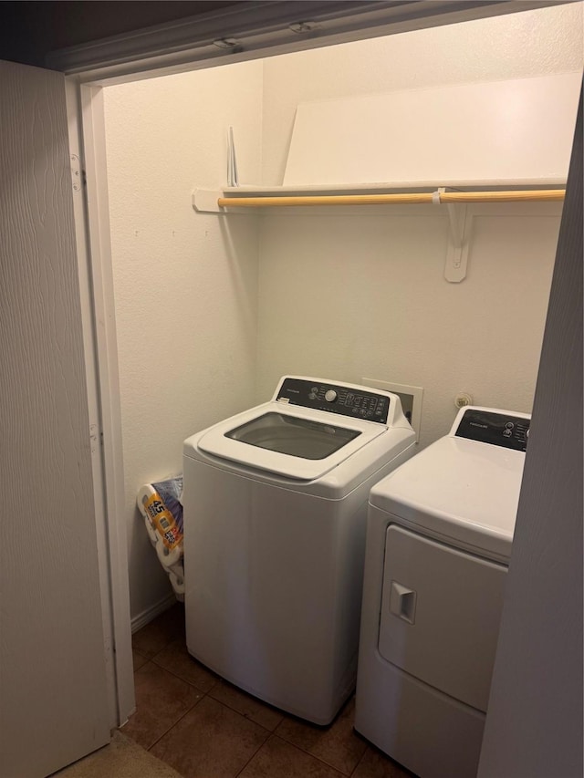 laundry room with laundry area, dark tile patterned flooring, and washer and dryer