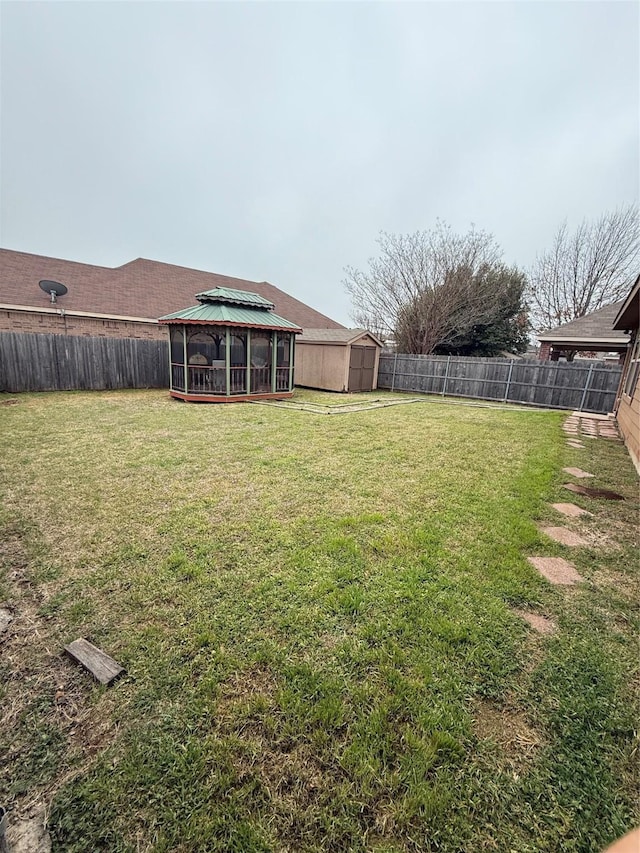 view of yard featuring a fenced backyard, an outdoor structure, a gazebo, and a shed