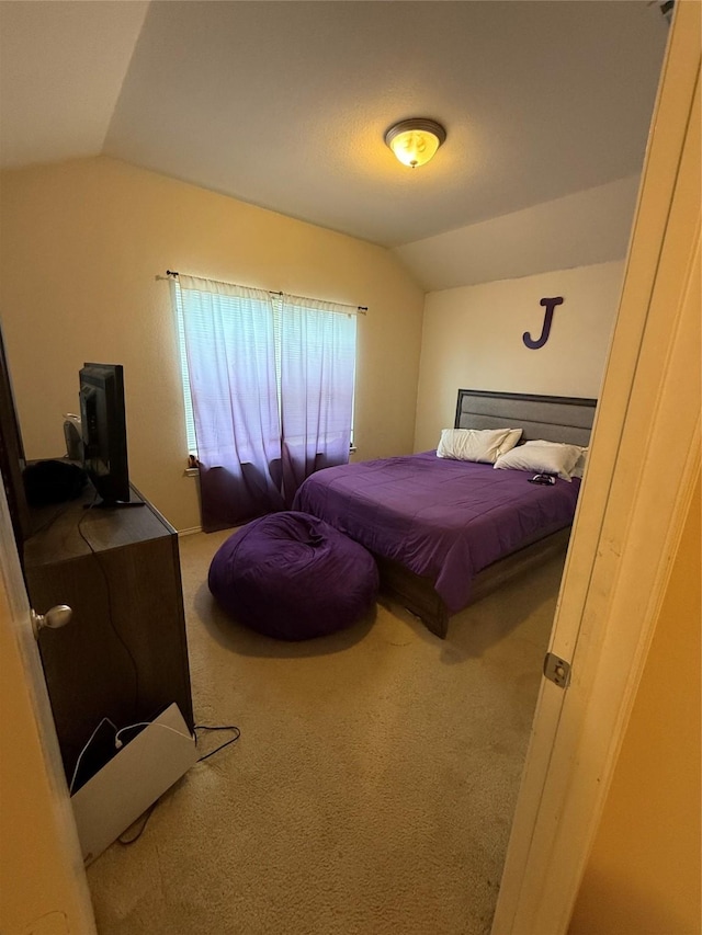 carpeted bedroom featuring lofted ceiling