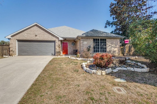 single story home featuring driveway, brick siding, a shingled roof, an attached garage, and a front yard