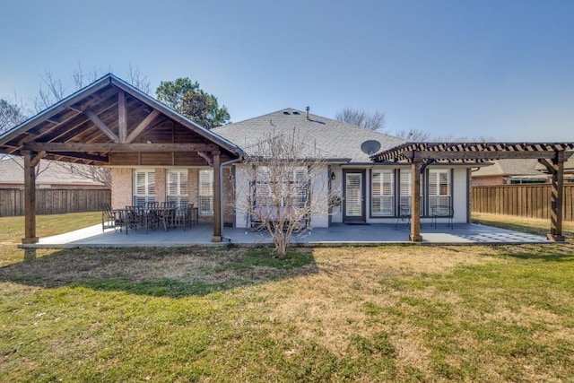 rear view of property featuring a yard, fence, and a patio