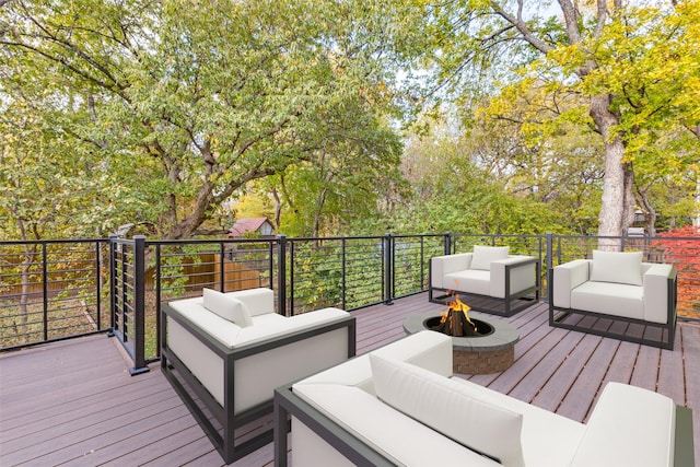 wooden terrace featuring an outdoor living space with a fire pit