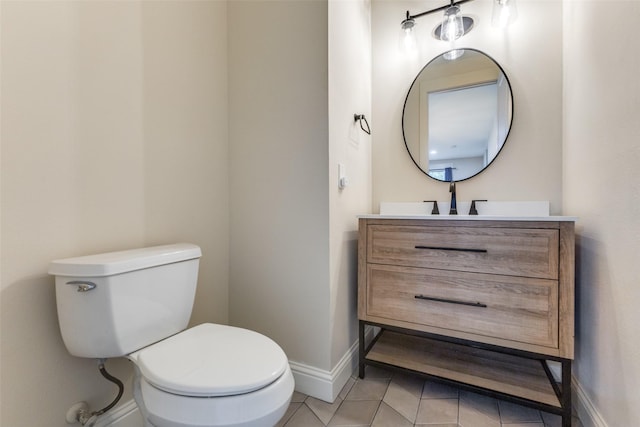 half bathroom with toilet, baseboards, tile patterned flooring, and vanity