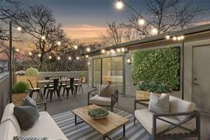 patio terrace at dusk with outdoor dining space and an outdoor hangout area