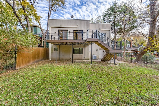 back of house featuring central air condition unit, a lawn, stairway, fence, and a deck