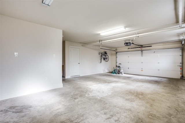 garage featuring a garage door opener and baseboards