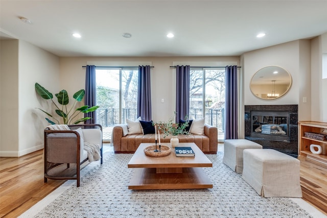 living room with wood finished floors, recessed lighting, a high end fireplace, and a wealth of natural light