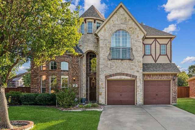 french country style house with an attached garage, concrete driveway, and a front yard