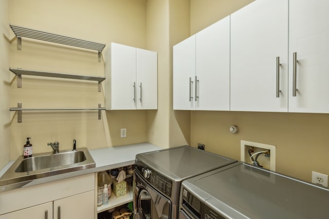 laundry room with cabinet space, separate washer and dryer, and a sink