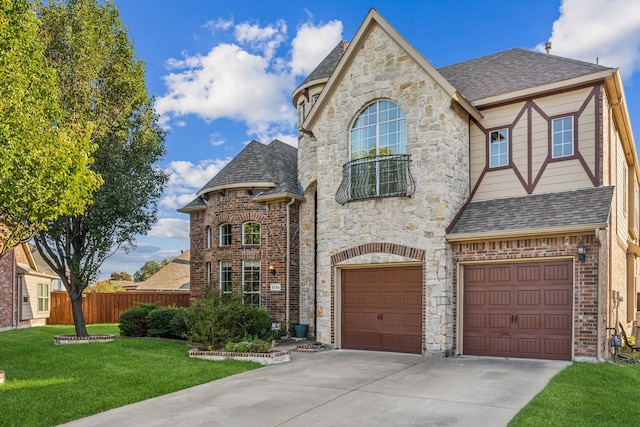 french country inspired facade featuring brick siding, concrete driveway, an attached garage, fence, and a front yard