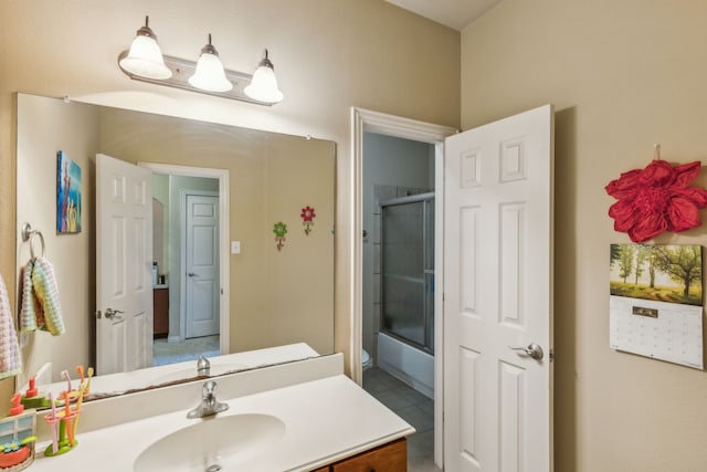 bathroom featuring tile patterned flooring, enclosed tub / shower combo, and vanity