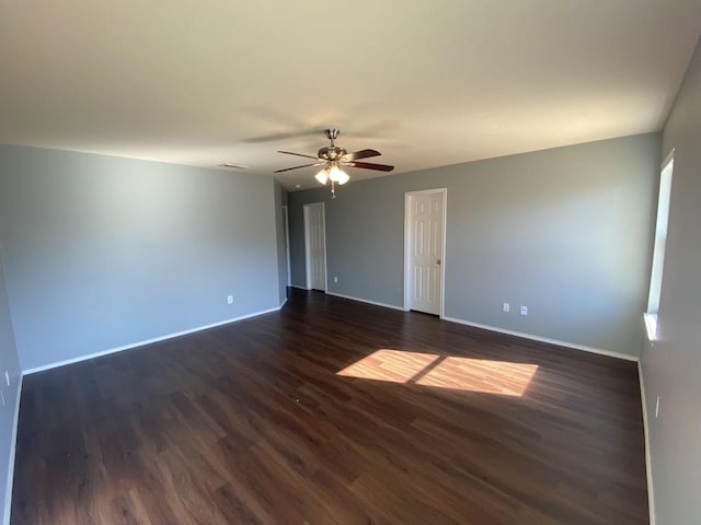 unfurnished room with a ceiling fan, dark wood-style flooring, and baseboards