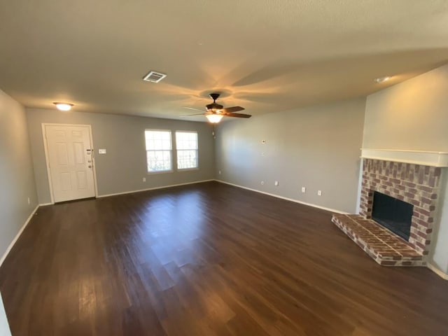 unfurnished living room featuring baseboards, visible vents, a ceiling fan, dark wood-style flooring, and a fireplace