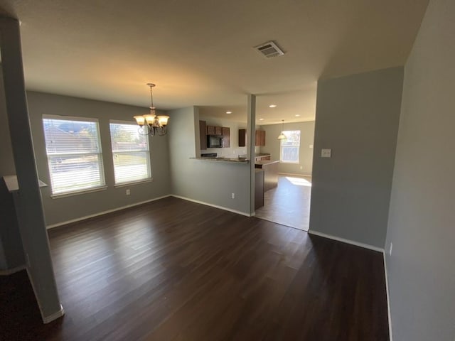 interior space featuring dark wood-style flooring, a notable chandelier, recessed lighting, visible vents, and baseboards