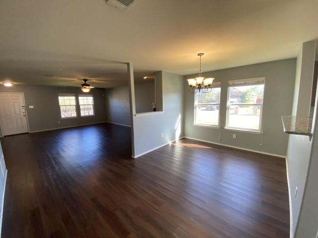 unfurnished living room with visible vents, dark wood finished floors, baseboards, and ceiling fan with notable chandelier