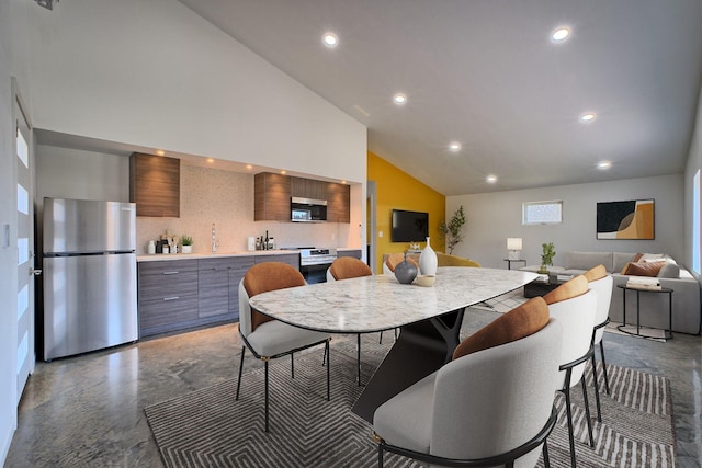 dining space featuring high vaulted ceiling, concrete floors, and recessed lighting