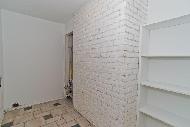 clothes washing area with brick wall and stone finish floor