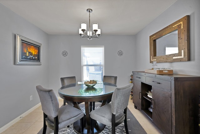 dining space with baseboards, a notable chandelier, and light tile patterned flooring