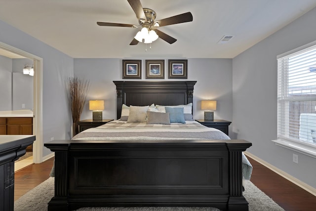 bedroom featuring baseboards, visible vents, a ceiling fan, connected bathroom, and dark wood-style flooring