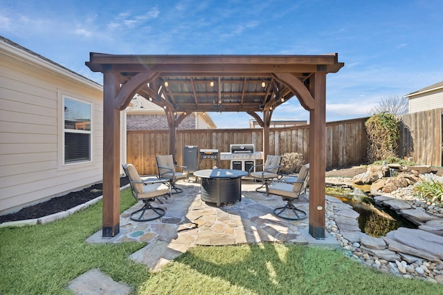 view of patio with a fire pit, a gazebo, grilling area, and fence