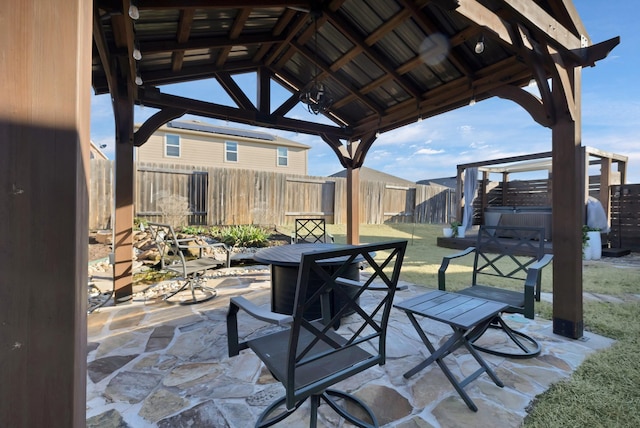 view of patio with outdoor dining space, a fenced backyard, and a gazebo