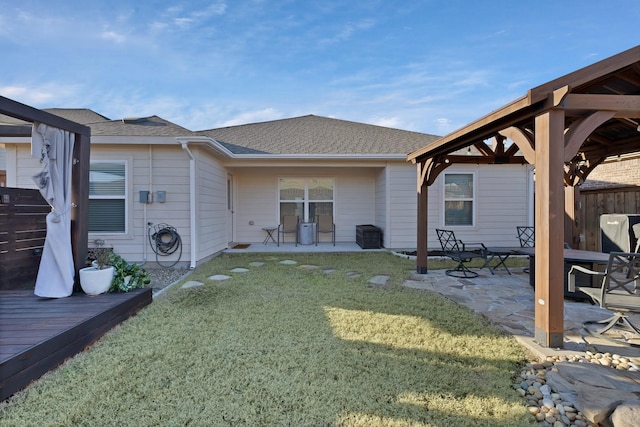 back of house with a shingled roof, a patio, a yard, fence, and a gazebo