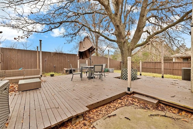 wooden deck featuring outdoor dining area and a fenced backyard