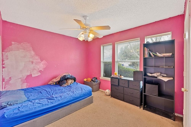 bedroom featuring carpet floors, ceiling fan, baseboards, and a textured ceiling