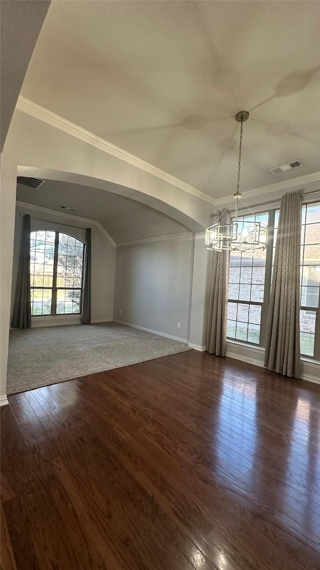 interior space with dark wood-style floors, crown molding, visible vents, a chandelier, and baseboards