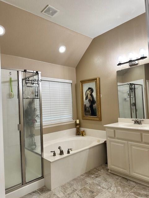 bathroom with visible vents, a stall shower, vaulted ceiling, vanity, and a bath