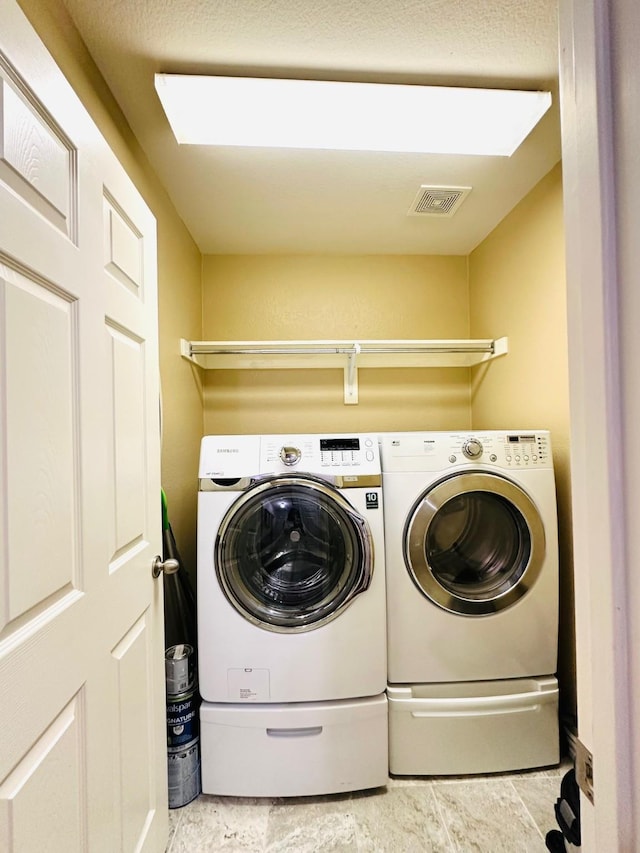 laundry room featuring laundry area, visible vents, and separate washer and dryer