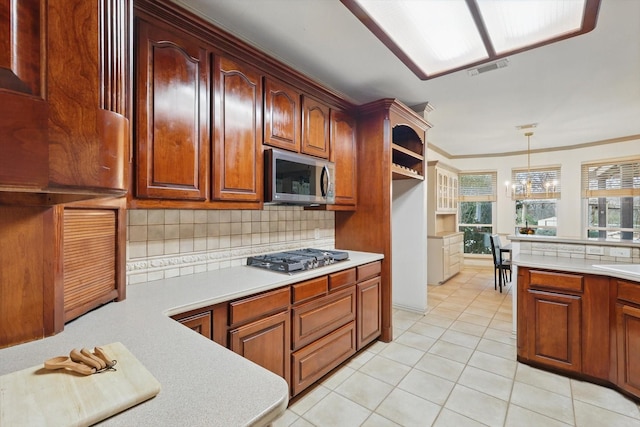 kitchen featuring appliances with stainless steel finishes, light countertops, decorative light fixtures, and decorative backsplash