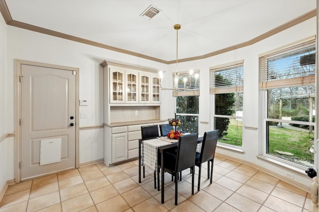 dining space with ornamental molding, light tile patterned flooring, and visible vents