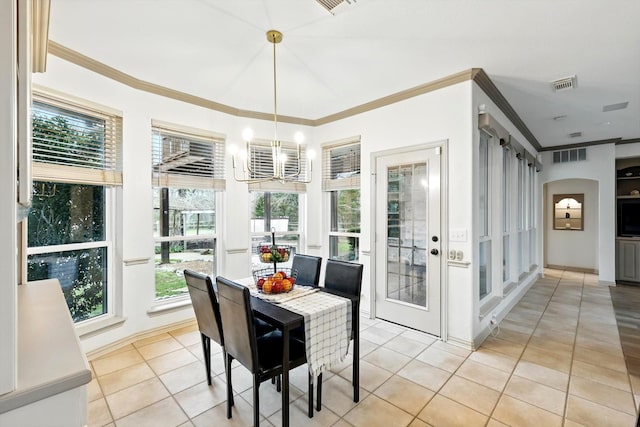 sunroom / solarium featuring an inviting chandelier, a barn door, and visible vents