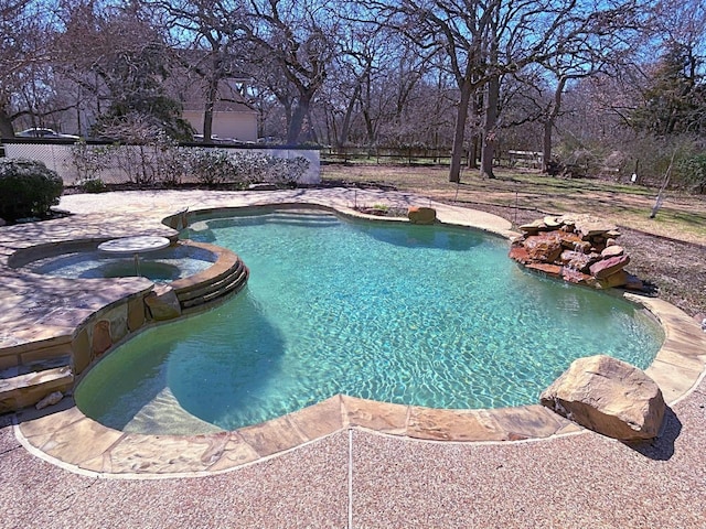 view of pool featuring a pool with connected hot tub and fence