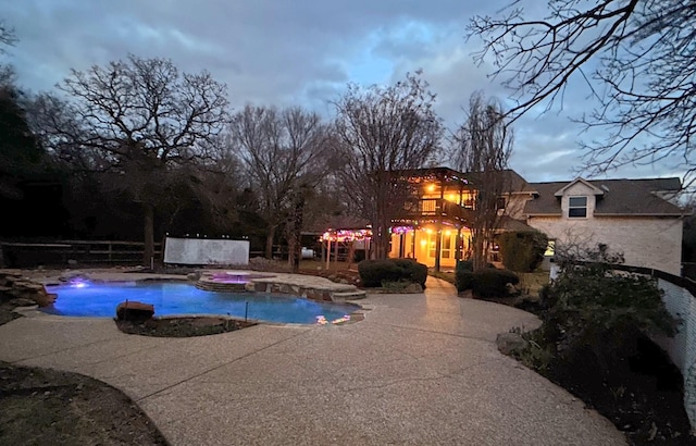 pool featuring fence, a patio, and an in ground hot tub