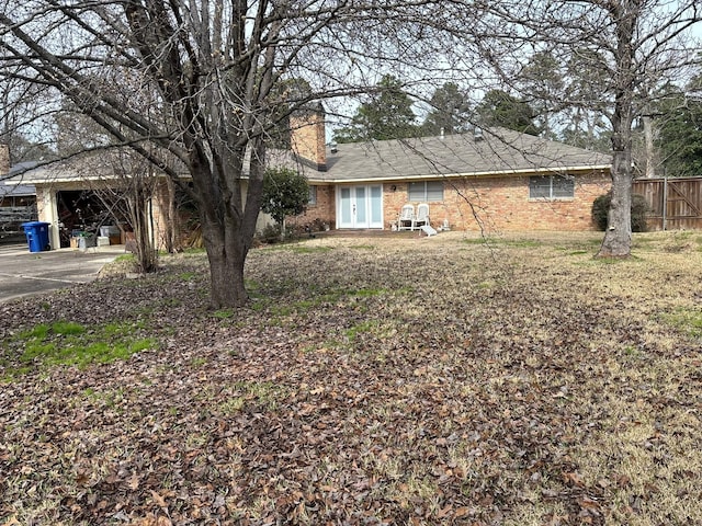 8418 W Wilderness Way, Shreveport, LA 71106 - view of yard with driveway, fence, french doors, and a carport