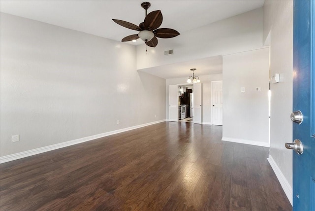 unfurnished living room featuring ceiling fan with notable chandelier, baseboards, visible vents, and dark wood-style flooring