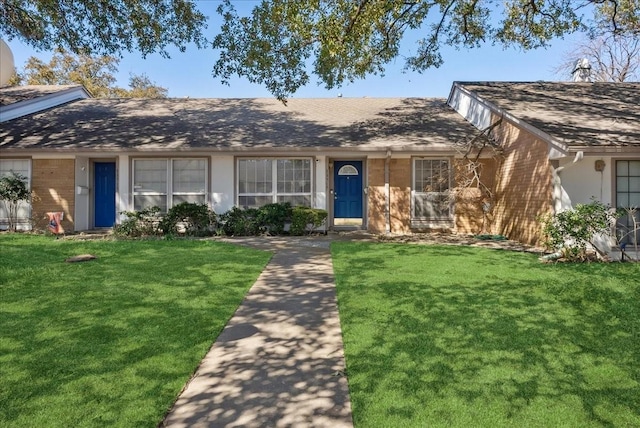 ranch-style home with a front lawn, brick siding, and stucco siding